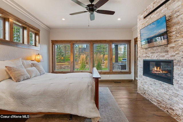 bedroom featuring multiple windows, ornamental molding, and wood finished floors