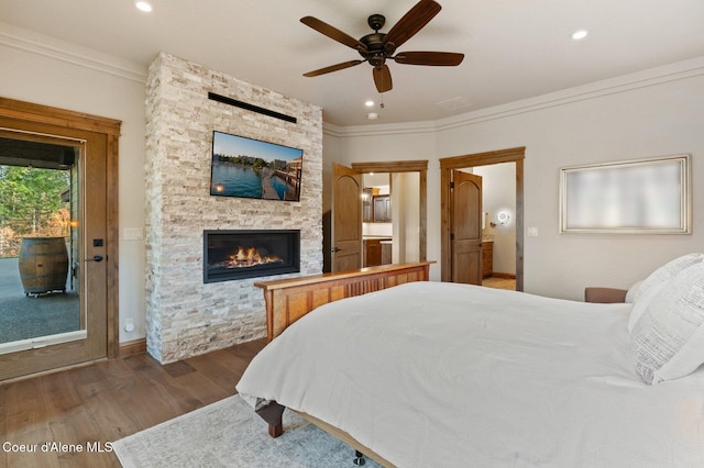 bedroom with recessed lighting, a fireplace, wood finished floors, access to exterior, and ornamental molding