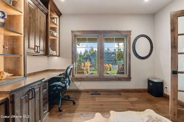 office area featuring wood finished floors, built in study area, and baseboards