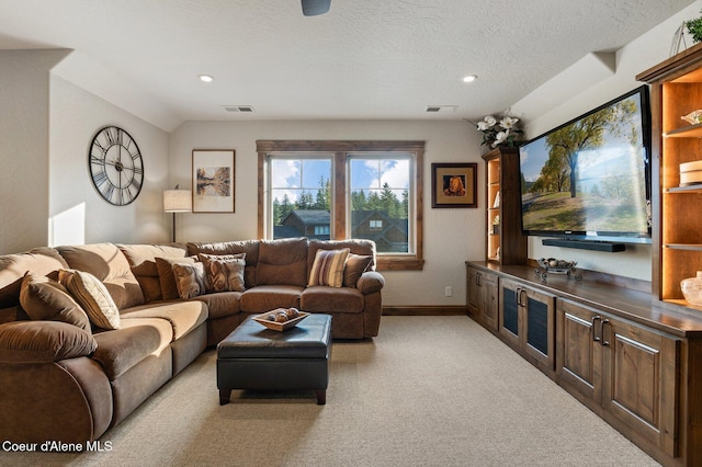 living area featuring a textured ceiling, baseboards, visible vents, and light colored carpet