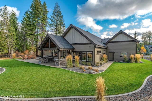 rear view of property featuring board and batten siding, a patio area, a lawn, and area for grilling