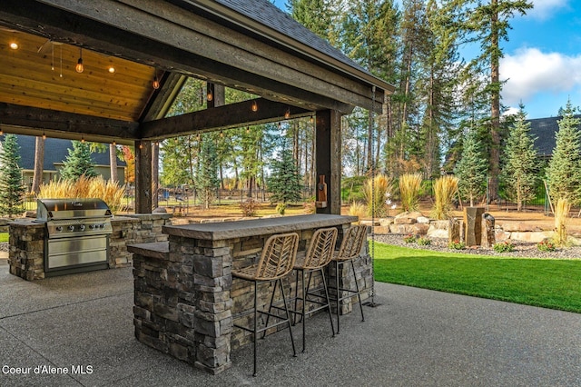 view of patio with exterior kitchen, a grill, outdoor dry bar, and a gazebo