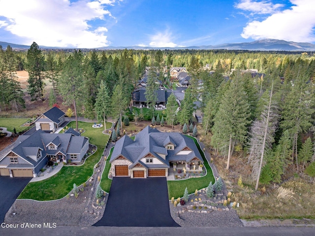 drone / aerial view featuring a wooded view