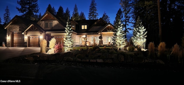 craftsman-style home featuring a garage, stone siding, and driveway