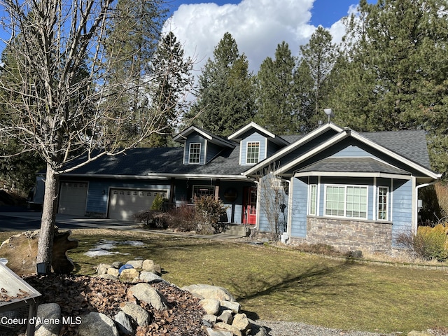 view of front of home featuring a garage, stone siding, a shingled roof, and a front lawn