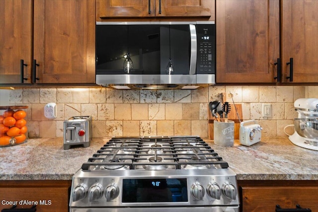 6489 E Kyong, Post Falls, ID 83854 - kitchen with stainless steel appliances, light countertops, decorative backsplash, and brown cabinets