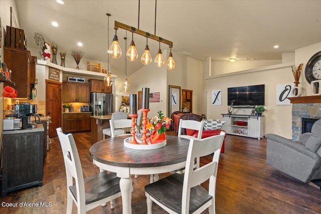 6489 E Kyong, Post Falls, ID 83854 - dining space with dark wood finished floors, vaulted ceiling, a fireplace, and recessed lighting