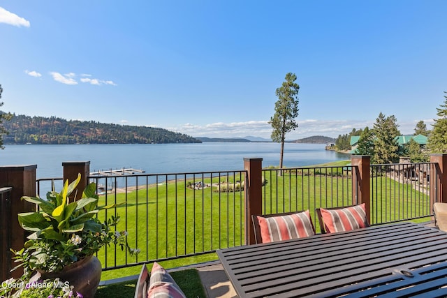 wooden terrace with a water view and a yard