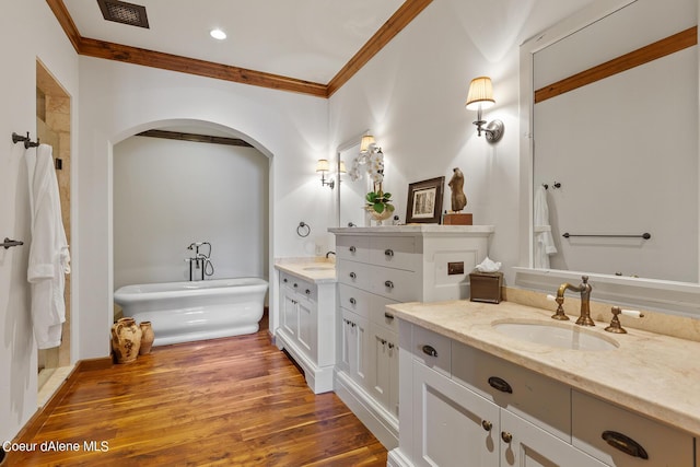 bathroom featuring wood finished floors, a sink, visible vents, and crown molding