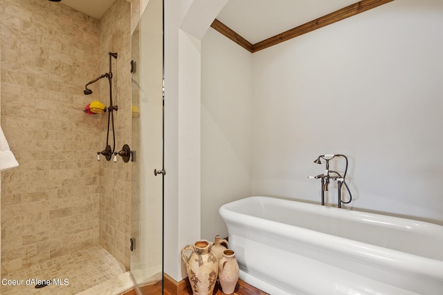 bathroom with a soaking tub, a shower stall, and crown molding