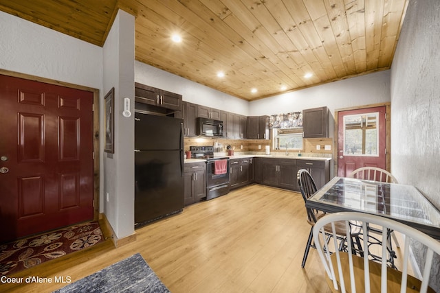 kitchen featuring black appliances, light wood-style floors, light countertops, wood ceiling, and a textured wall