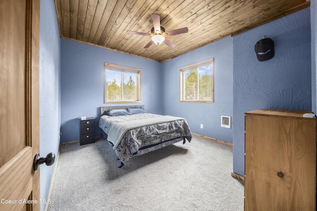 carpeted bedroom with baseboards, wood ceiling, a ceiling fan, and a textured wall