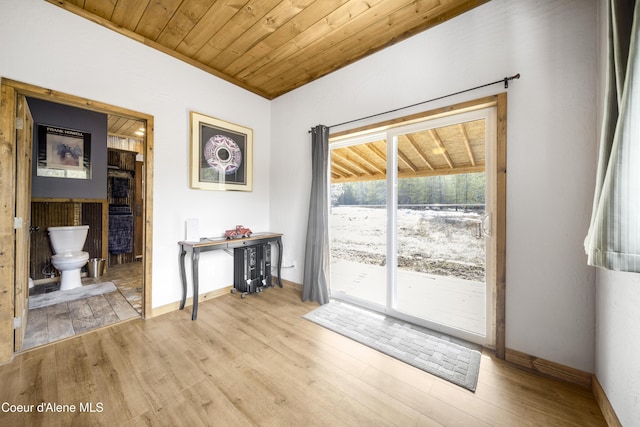 unfurnished dining area featuring wooden ceiling, light wood-style flooring, and baseboards