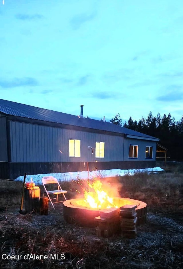 exterior space with a fire pit and metal roof