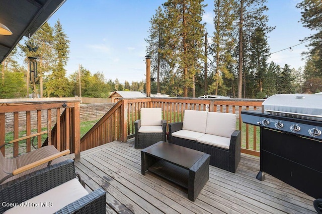 wooden terrace with area for grilling, fence, and an outdoor hangout area