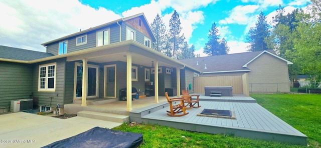 505 S Shore Pines Rd, Post Falls, ID 83854 - rear view of property featuring a hot tub, central AC unit, a lawn, and a wooden deck