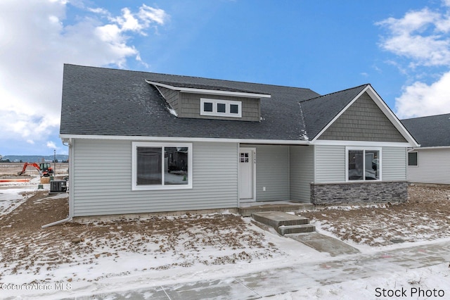 view of front of property with a shingled roof and cooling unit