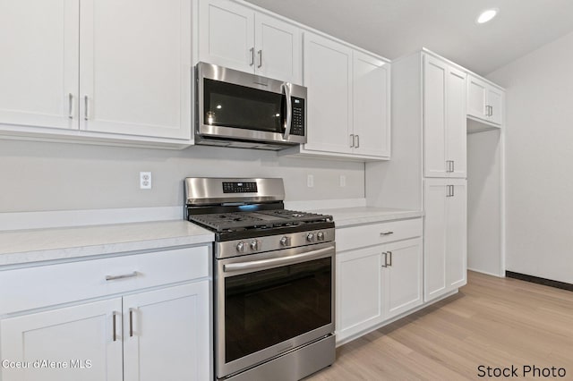 kitchen with stainless steel appliances, recessed lighting, light countertops, light wood-style floors, and white cabinets