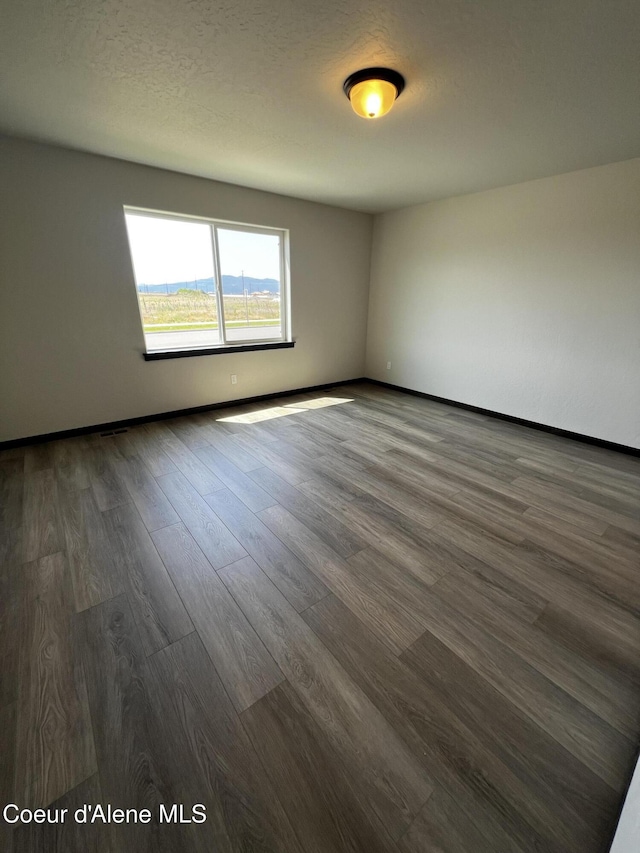 11557 N Railway Ave, Rathdrum, ID 83858 - spare room with dark wood finished floors and baseboards