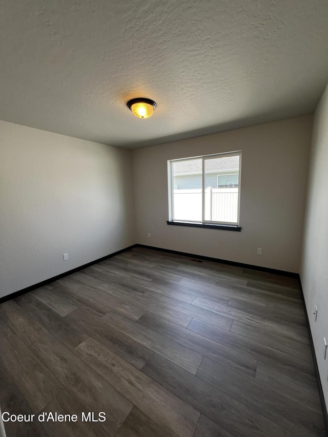 11557 N Railway Ave, Rathdrum, ID 83858 - spare room featuring dark wood-type flooring and a textured ceiling
