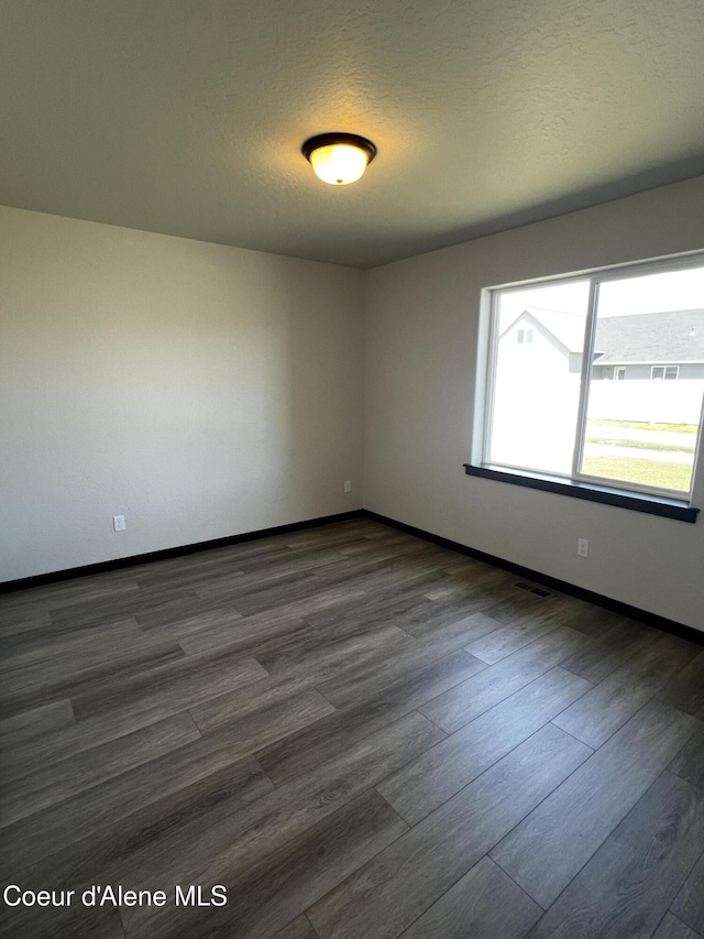 11557 N Railway Ave, Rathdrum, ID 83858 - spare room with dark wood-style flooring and baseboards