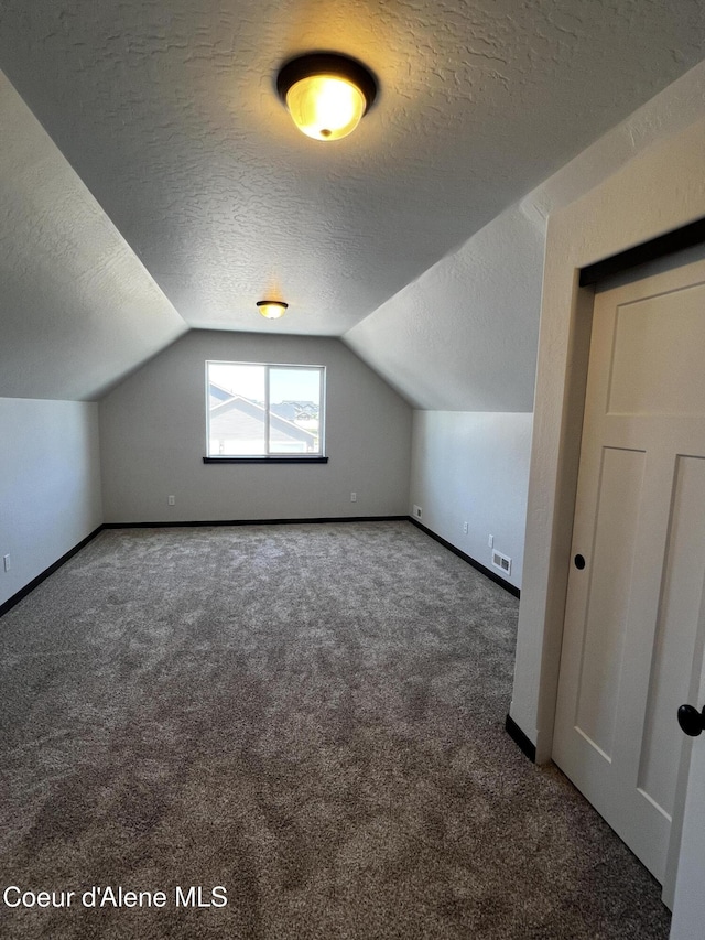11557 N Railway Ave, Rathdrum, ID 83858 - bonus room featuring a textured ceiling, carpet, and lofted ceiling