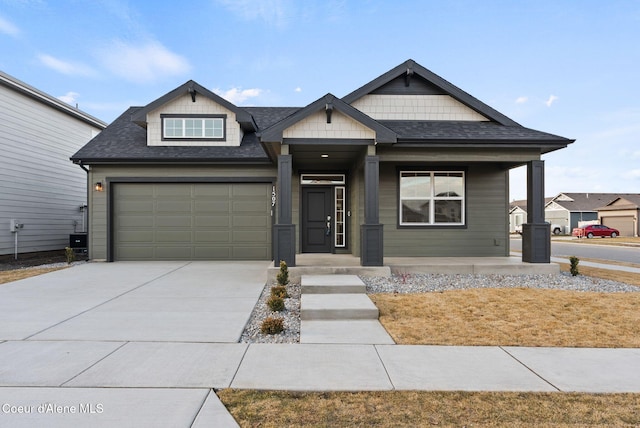 craftsman house featuring a garage, driveway, and a shingled roof