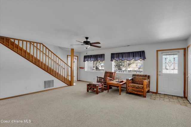 sitting room featuring a healthy amount of sunlight, visible vents, carpet flooring, and stairs