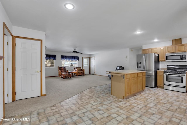 kitchen featuring recessed lighting, light colored carpet, stainless steel appliances, open floor plan, and light countertops