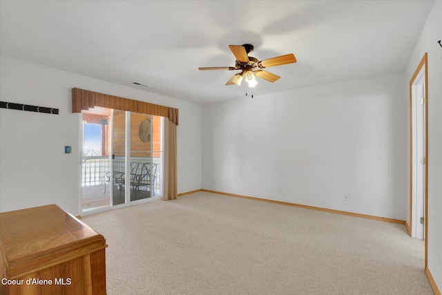 spare room featuring light carpet, ceiling fan, and baseboards