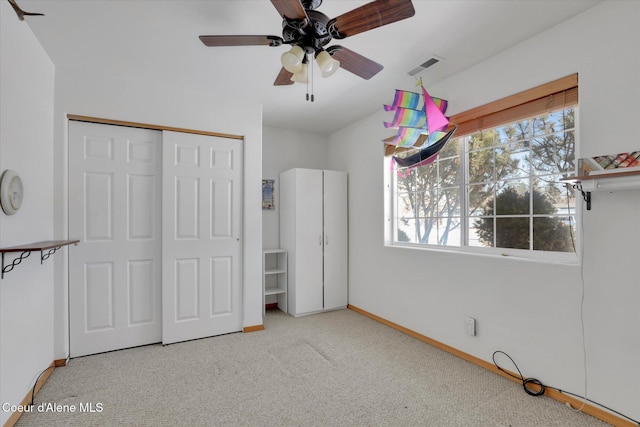 unfurnished bedroom with baseboards, visible vents, ceiling fan, carpet flooring, and a closet