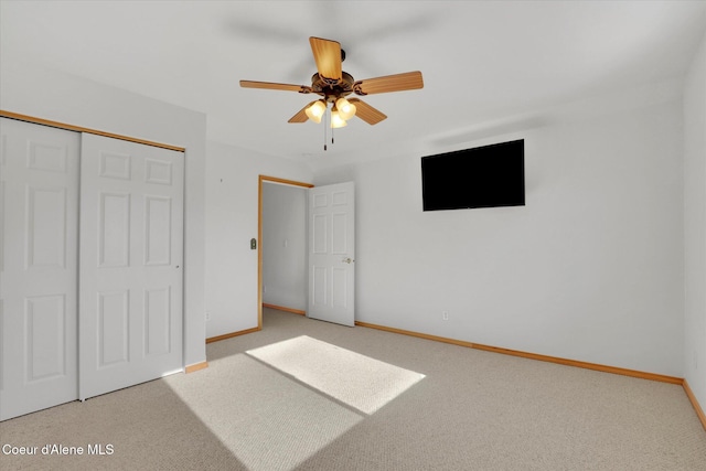 unfurnished bedroom with a ceiling fan, a closet, carpet flooring, and baseboards