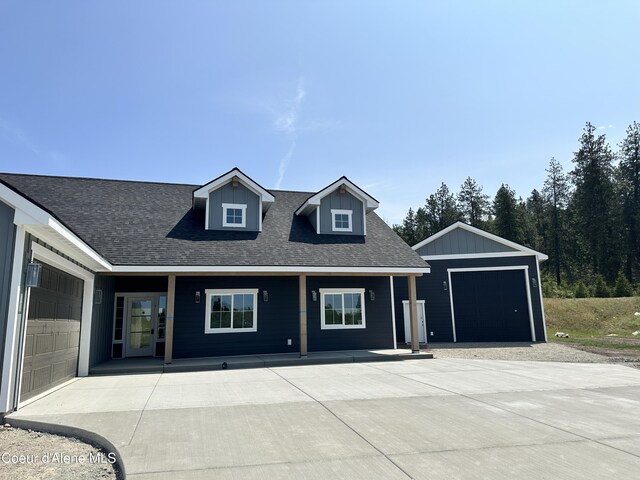 4550 E Savea Ln, Post Falls, ID 83854 - view of front of house with a garage, a shingled roof, covered porch, and an outdoor structure