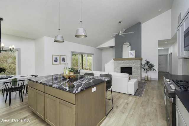 4550 E Savea Ln, Post Falls, ID 83854 - kitchen with a chandelier, a kitchen island, light wood-type flooring, a ceiling fan, and high vaulted ceiling