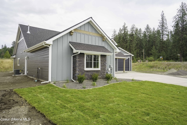 4550 E Savea Ln, Post Falls, ID 83854 - view of front of home featuring board and batten siding, driveway, an attached garage, a front yard, and a shingled roof