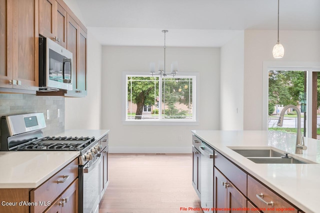 kitchen with appliances with stainless steel finishes, plenty of natural light, a sink, and backsplash