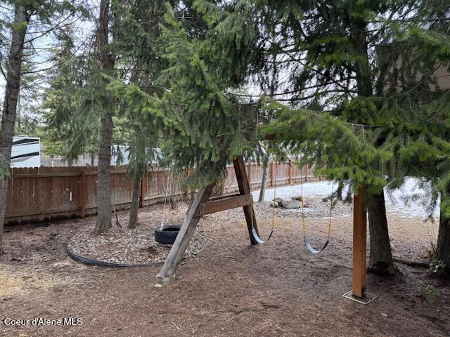 view of yard featuring fence and playground community