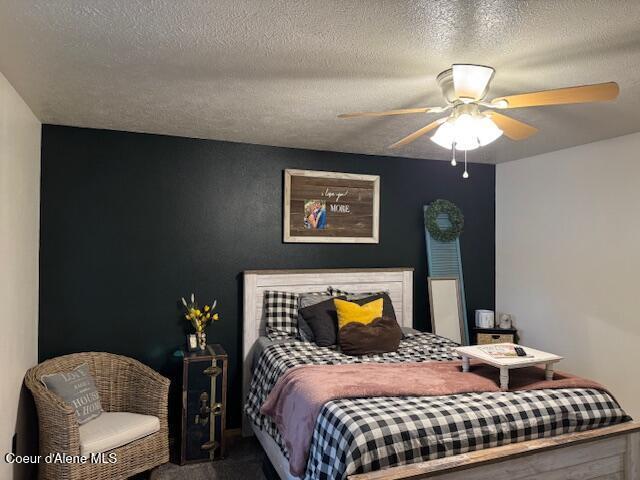 carpeted bedroom with a ceiling fan and a textured ceiling