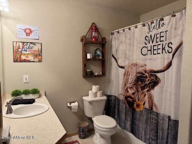 bathroom with baseboards, a shower with shower curtain, toilet, tile patterned flooring, and vanity