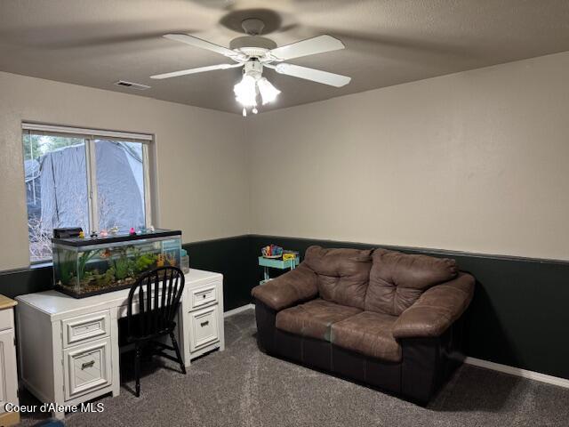 home office featuring a ceiling fan, dark colored carpet, visible vents, and baseboards