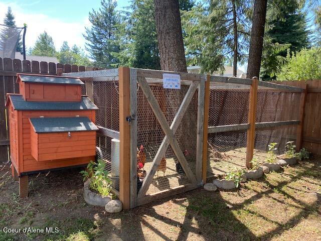 view of gate featuring fence, exterior structure, and an outbuilding