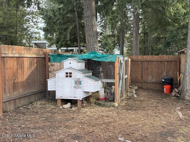 view of yard featuring an outdoor structure, a fenced backyard, and exterior structure