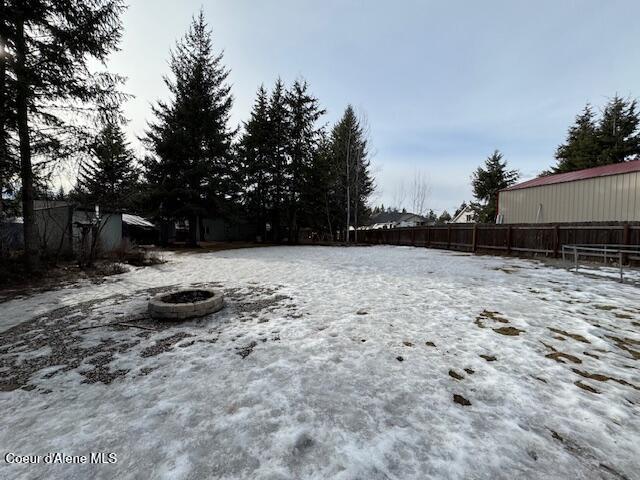 view of yard featuring an outdoor fire pit and fence