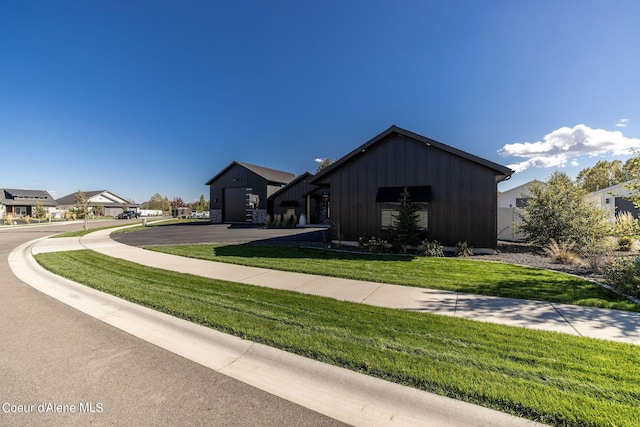 view of front of property with board and batten siding, a front yard, and a residential view