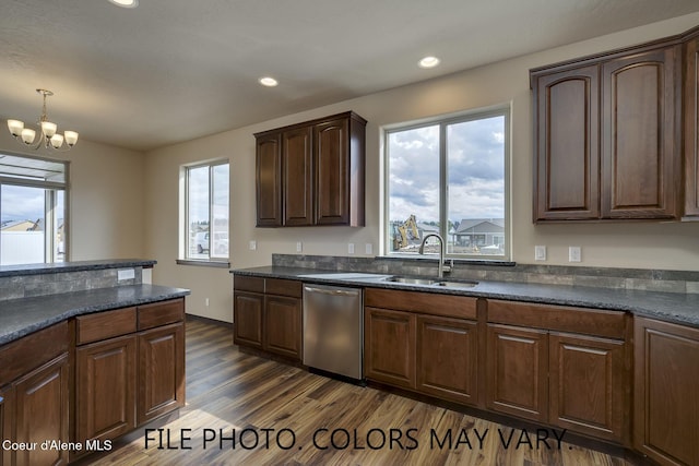 kitchen with stainless steel dishwasher, dark wood-type flooring, a sink, and a wealth of natural light