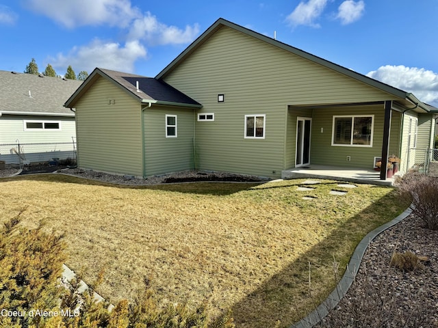 rear view of house with a patio area, fence, and a yard