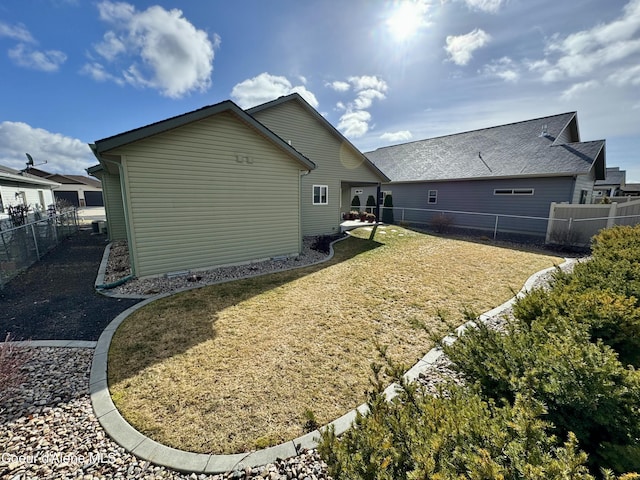 rear view of house with a fenced backyard and a lawn