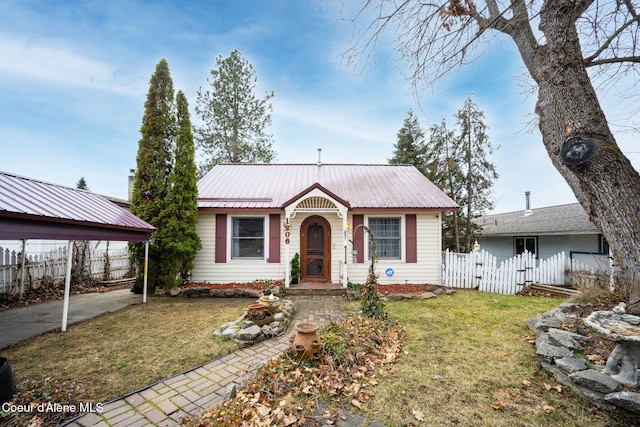 view of front of property with a carport, metal roof, fence, and a front lawn