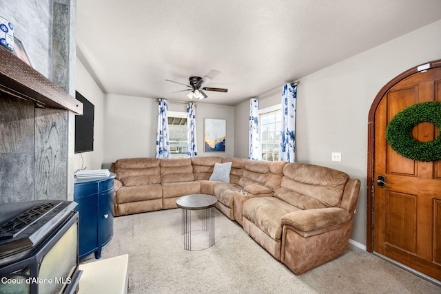 living area featuring light carpet, arched walkways, and a ceiling fan