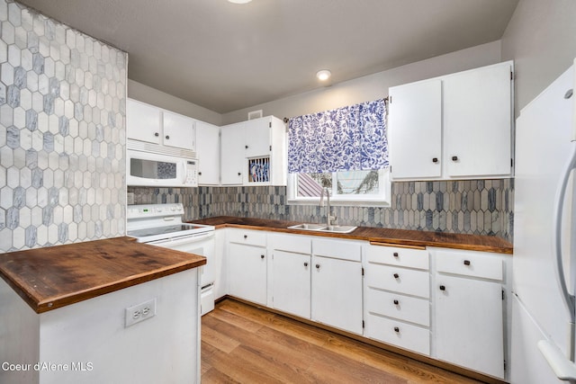 kitchen featuring white cabinets, white appliances, backsplash, and a sink